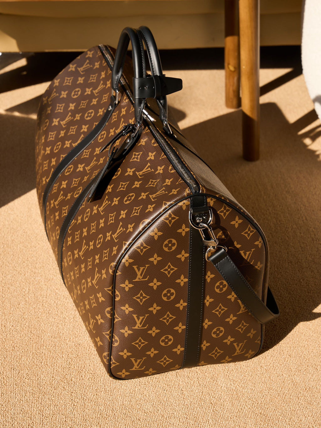 Monogram duffel bag with black leather shoulder strap and end zip pocket