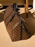 Monogram duffel bag with black leather shoulder strap and end zip pocket