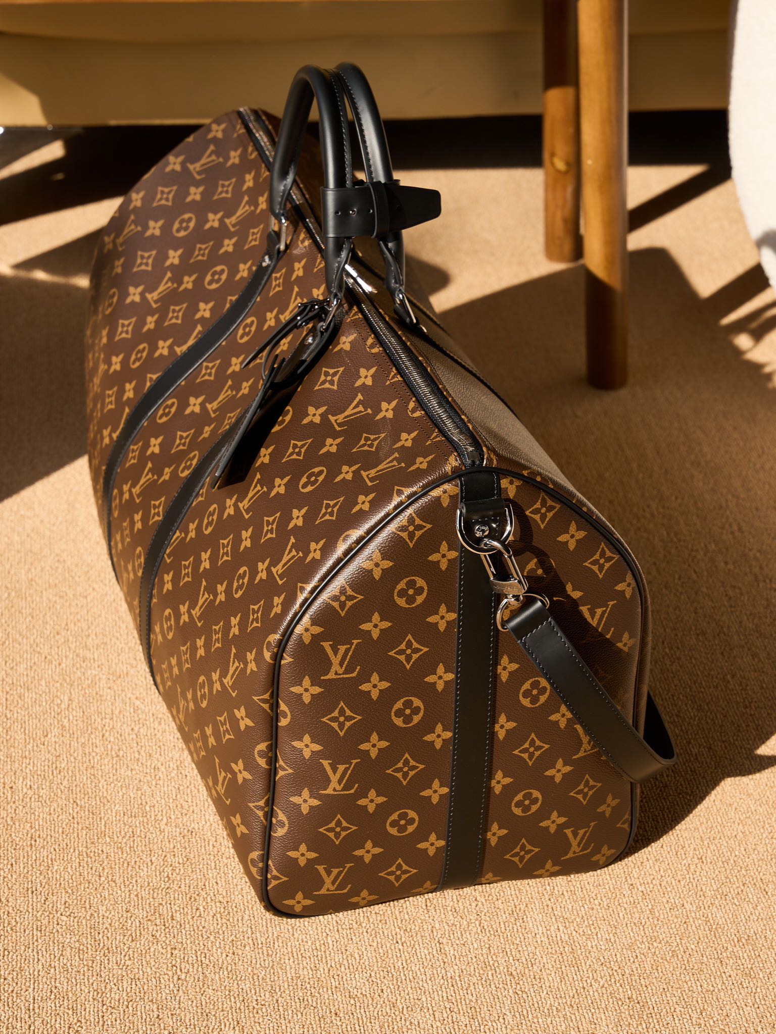 Monogram duffel bag with black leather shoulder strap and end zip pocket