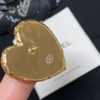 Heart-shaped gold-tone brooch back on white Bijoux Fantaisie card