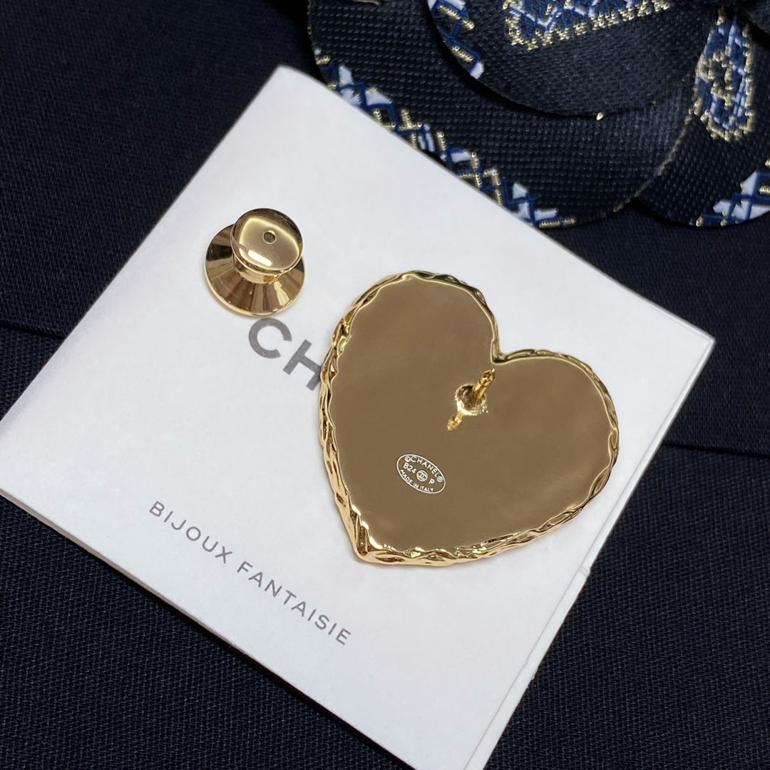 Heart-shaped gold-tone brooch with circular back piece on white Bijoux Fantaisie card