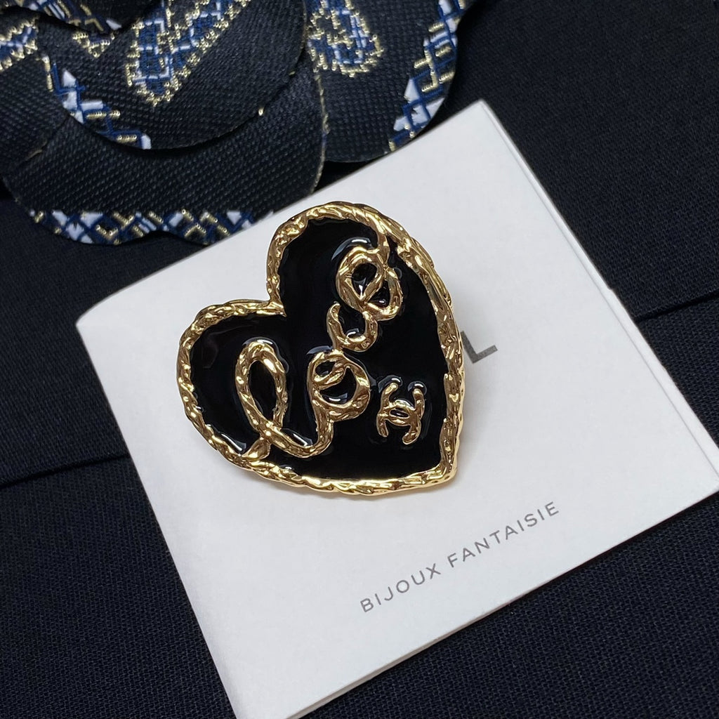 Heart-shaped gold-tone brooch with black center on white Bijoux Fantaisie card