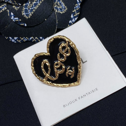 Heart-shaped gold-tone brooch with black center on white Bijoux Fantaisie card