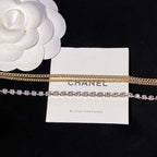 Layered gold chain and purple crystal tennis-style necklace on display card