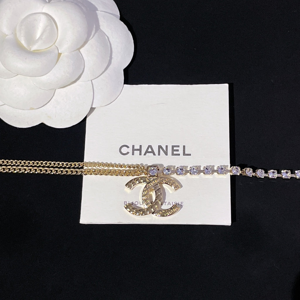 Gold chain necklace with purple crystal row and circular CC pendant charm