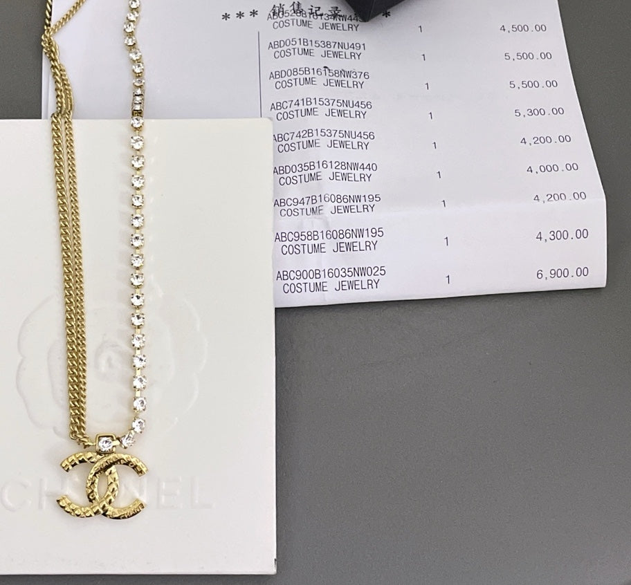 Crystal bead necklace and gold chain with clasp shown beside jewelry box label