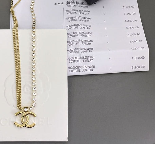 Crystal bead necklace and gold chain with clasp shown beside jewelry box label