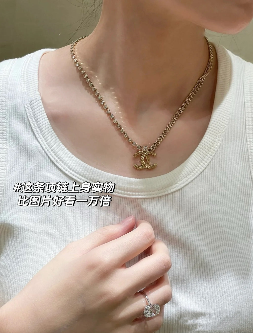 Gold-tone pearl-bead necklace with Chanel logo charm, close-up