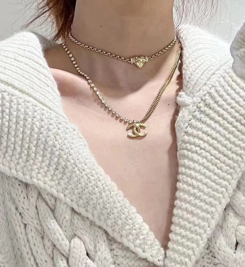 Layered gold-tone and pearl-bead necklaces with Chanel logo charms
