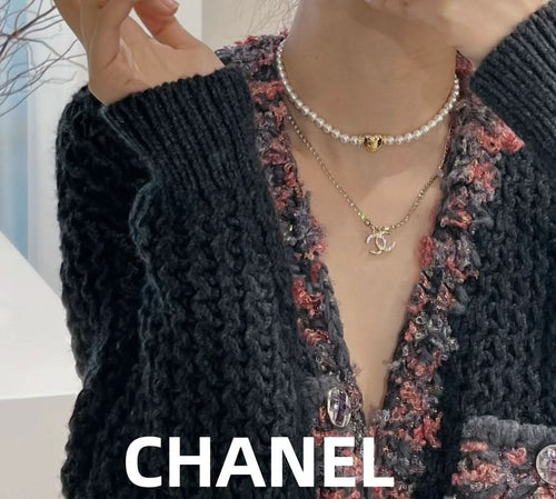 Layered pearl and gold-tone chain necklaces with small Chanel logo pendant