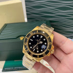 Rolex watch with black dial, gold-tone bezel markers, and link bracelet