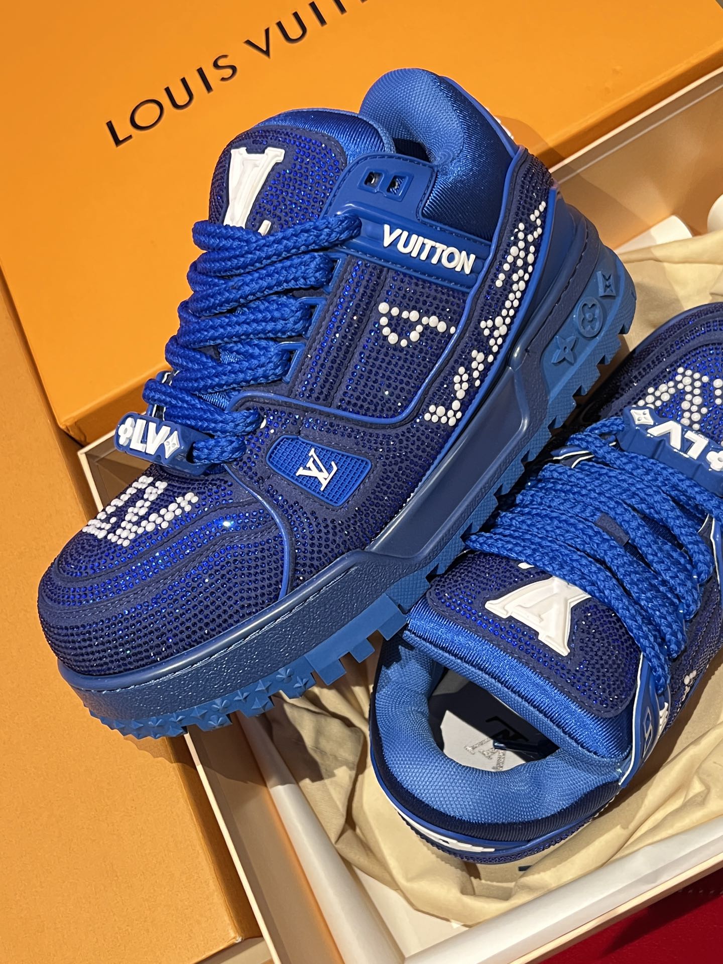 Blue lace-up sneakers with rhinestone trim and raised side emblem