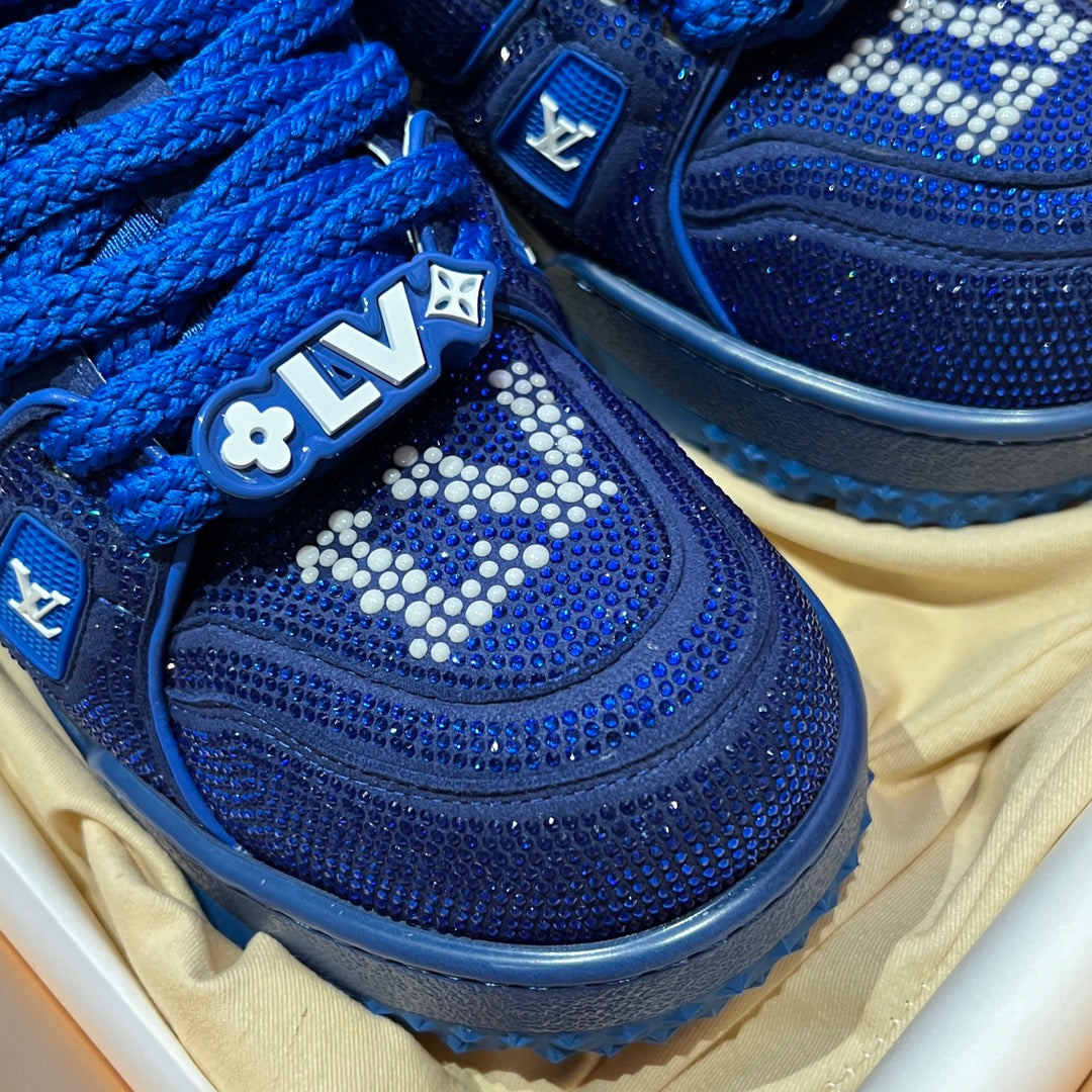 Close-up of blue lace-up sneaker with rhinestone logo on toe
