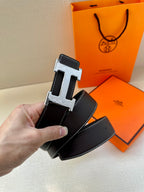 Hermes leather belt end, dark strap with silver buckle and visible punched holes