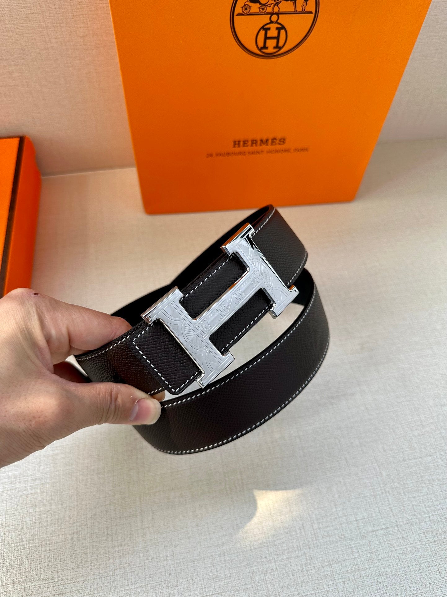 Hermes leather belt detail, dark textured leather with silver buckle and stitched panel