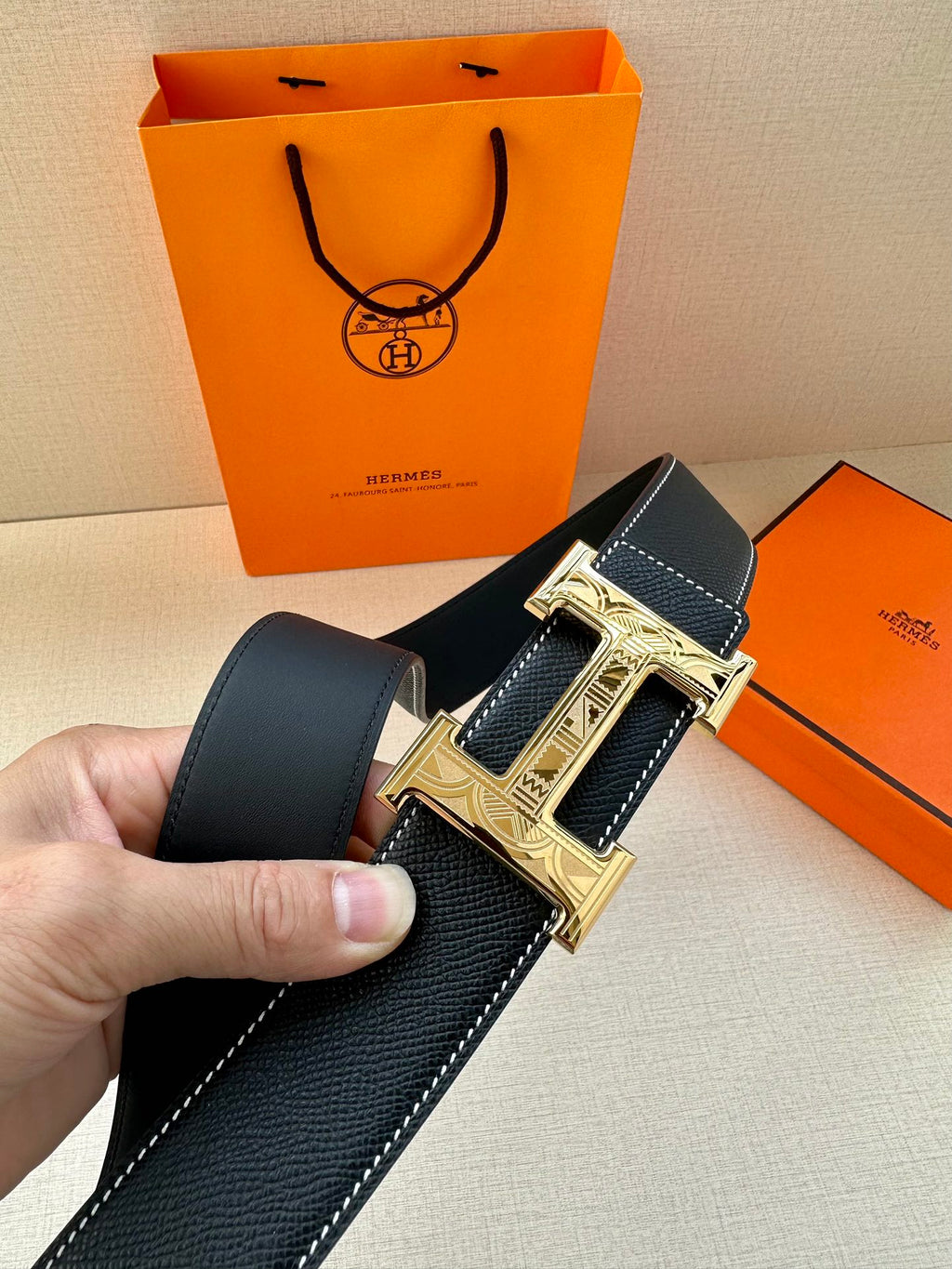 Hermes belt close-up, dark navy leather with silver H buckle and embossed frame