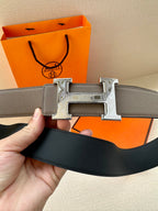Gray leather belt with silver-tone H buckle and leather keeper