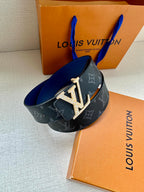 Louis Vuitton wide monogram belt with dark blue strap and gold LV buckle.