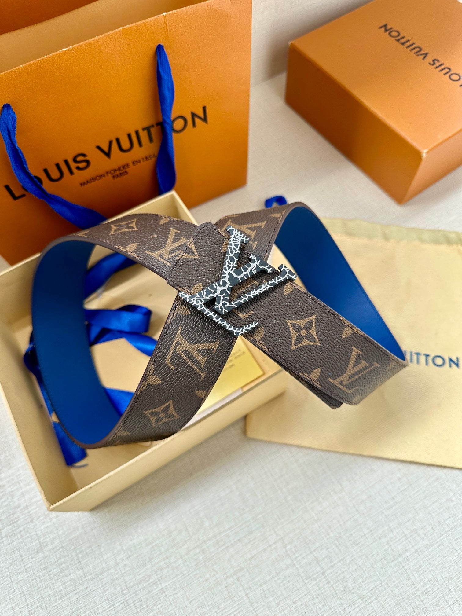 Monogram canvas belt with LV buckle, dark brown strap and blue edge detail
