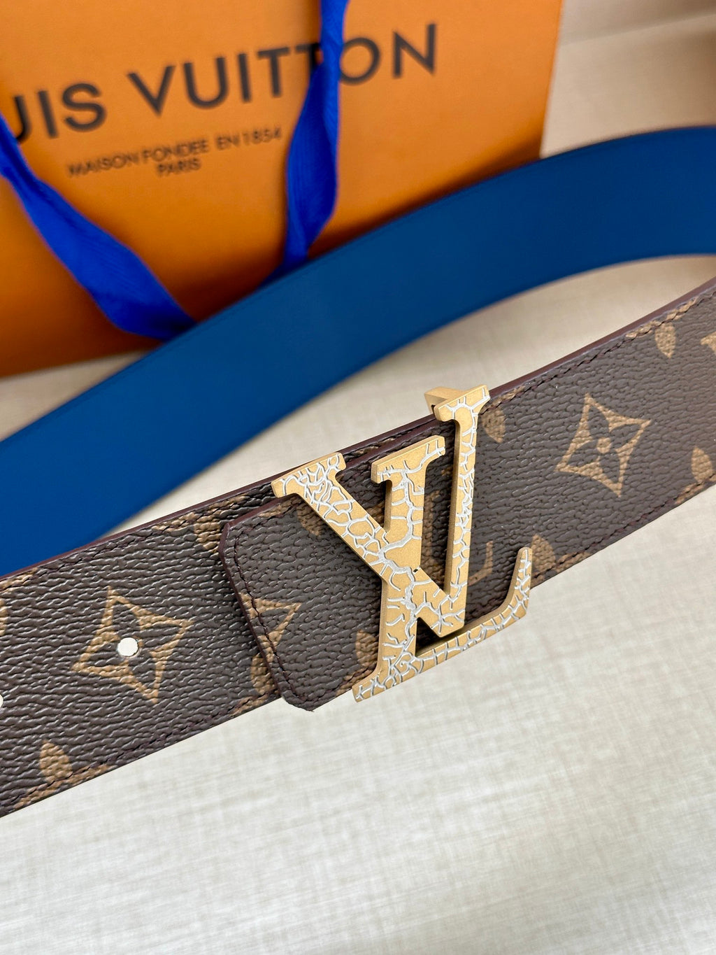 Monogram canvas belt strap with gold-tone LV buckle, patterned dark brown
