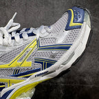 White, blue, and neon yellow sneakers with side logo detail and lace panel