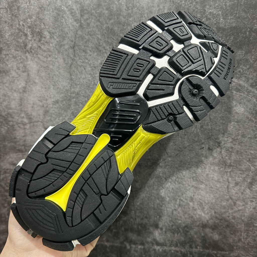 Black outsole with geometric tread and neon yellow midfoot stripe