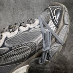 Side view of gray and white lace-up sneaker with layered uppers and thick sole