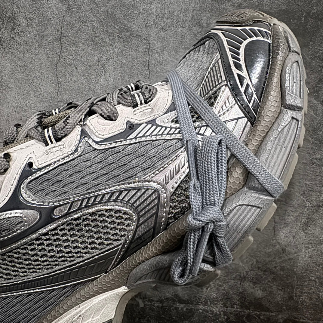 Side view of gray and white lace-up sneaker with layered uppers and thick sole