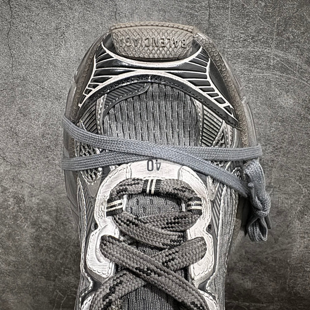 Gray and white sneaker toe area with lace-up fastening and textured knit panels