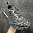 Gray and white lace-up sneaker with patterned overlays and chunky heel sole