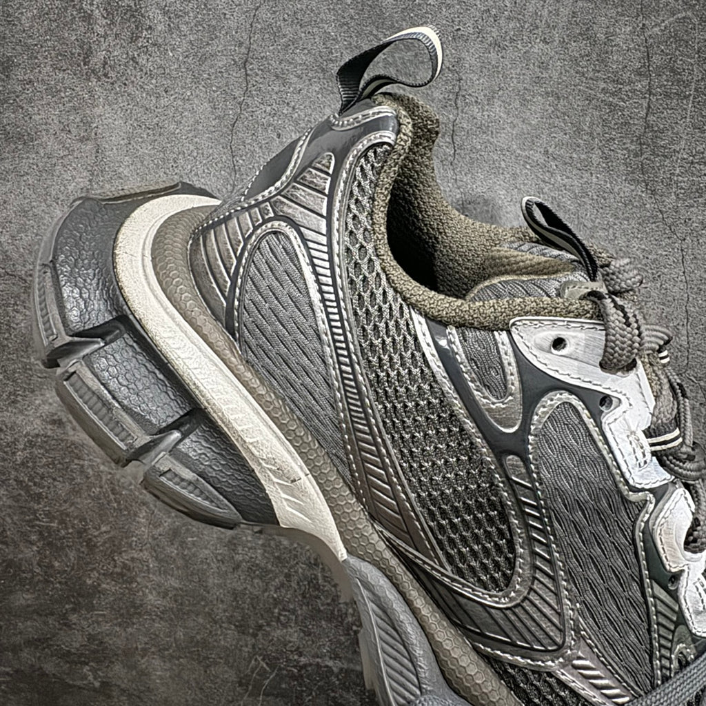 Gray and white mesh lace-up sneaker with swoosh-style logo and molded heel support