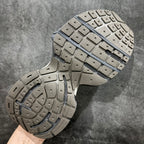 Gray sneaker outsole with rubber tread and blue stripe accent across midfoot