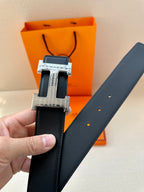 Black leather belt with silver-tone buckle and punched holes