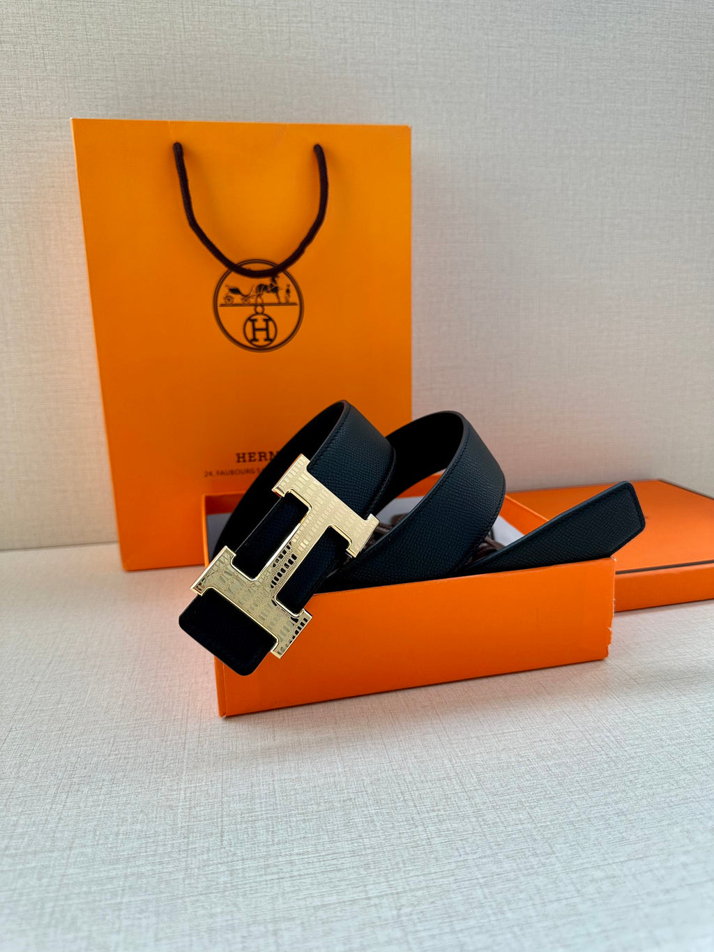 Black leather belt with silver-tone H buckle, side profile