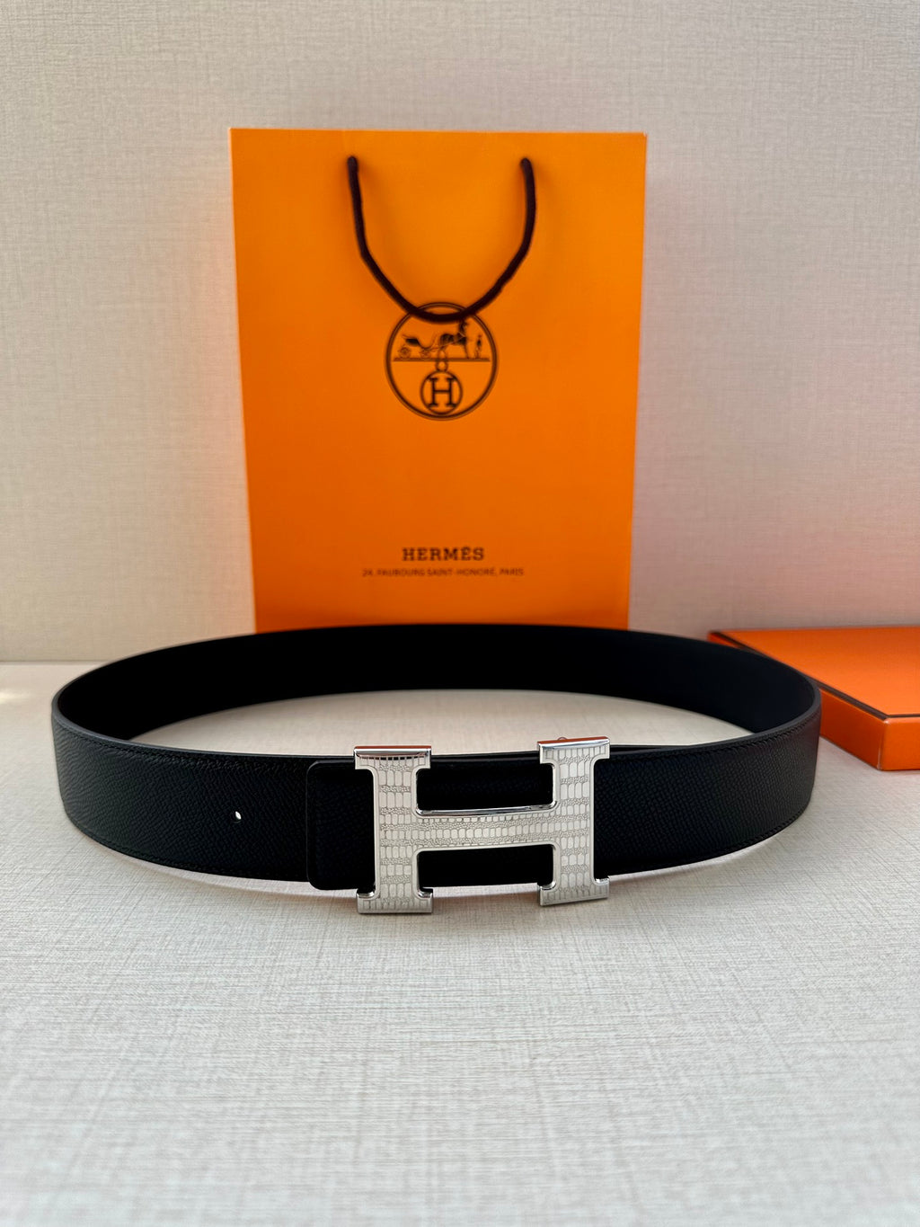 Black leather belt with silver-tone H buckle and keeper, centered