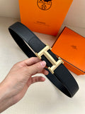 Hermes belt in dark textured leather with gold-toned geometric buckle and keeper.