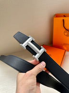 Hermes dark leather belt with silver-toned buckle and textured belt keeper detail.