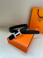 Hermes belt and buckle on box: dark leather strap with silver-toned rectangular clasp.