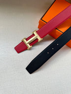 Red leather belt with gold H buckle, shown beside a dark leather belt.