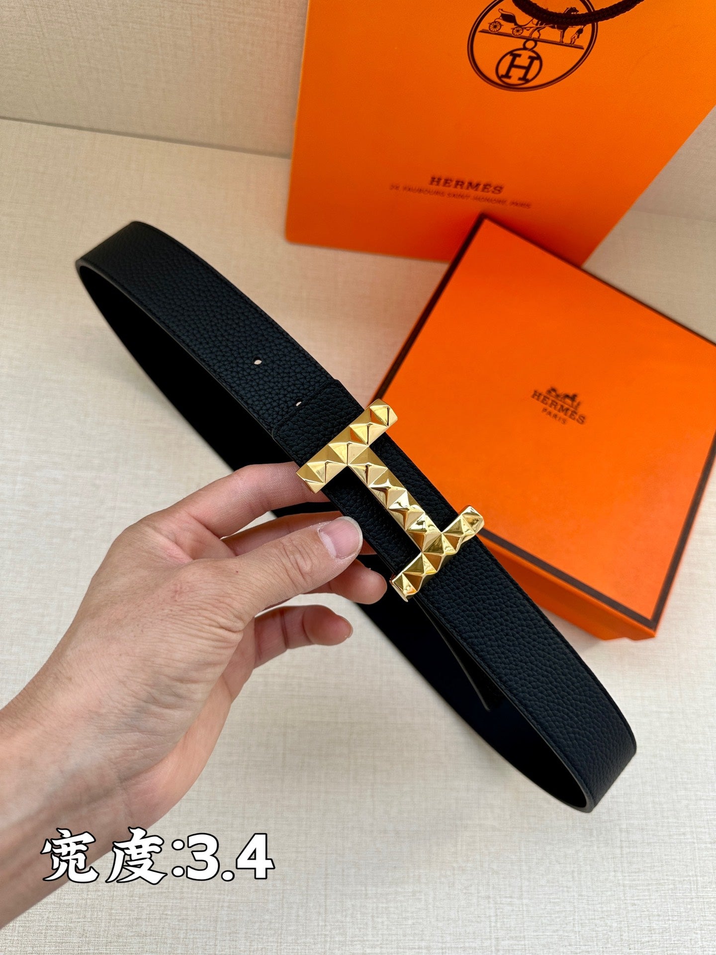 Black leather belt with textured silver-tone H buckle and prong closure.