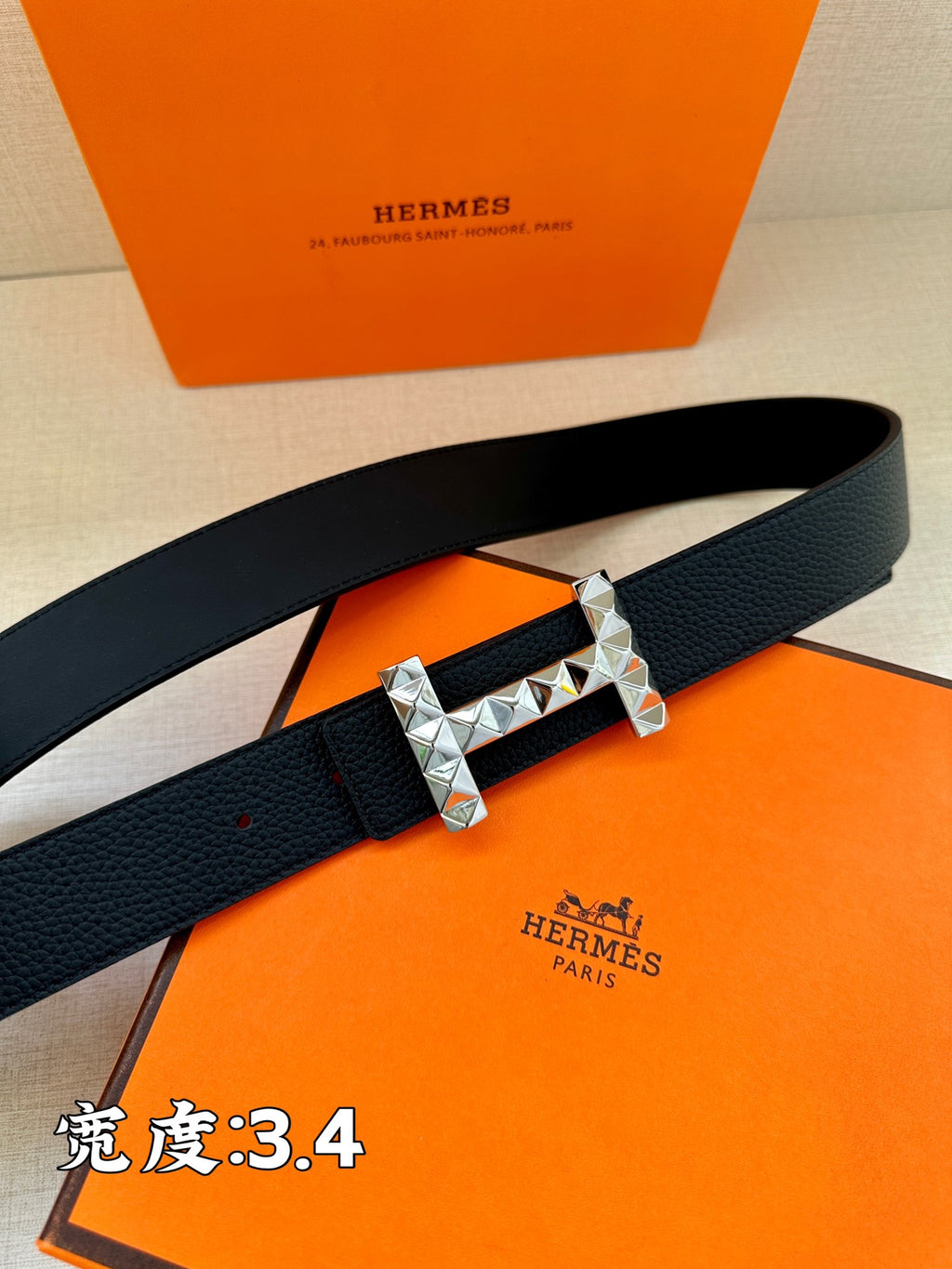 Black leather belt with silver-tone studded buckle and dark strap holes.