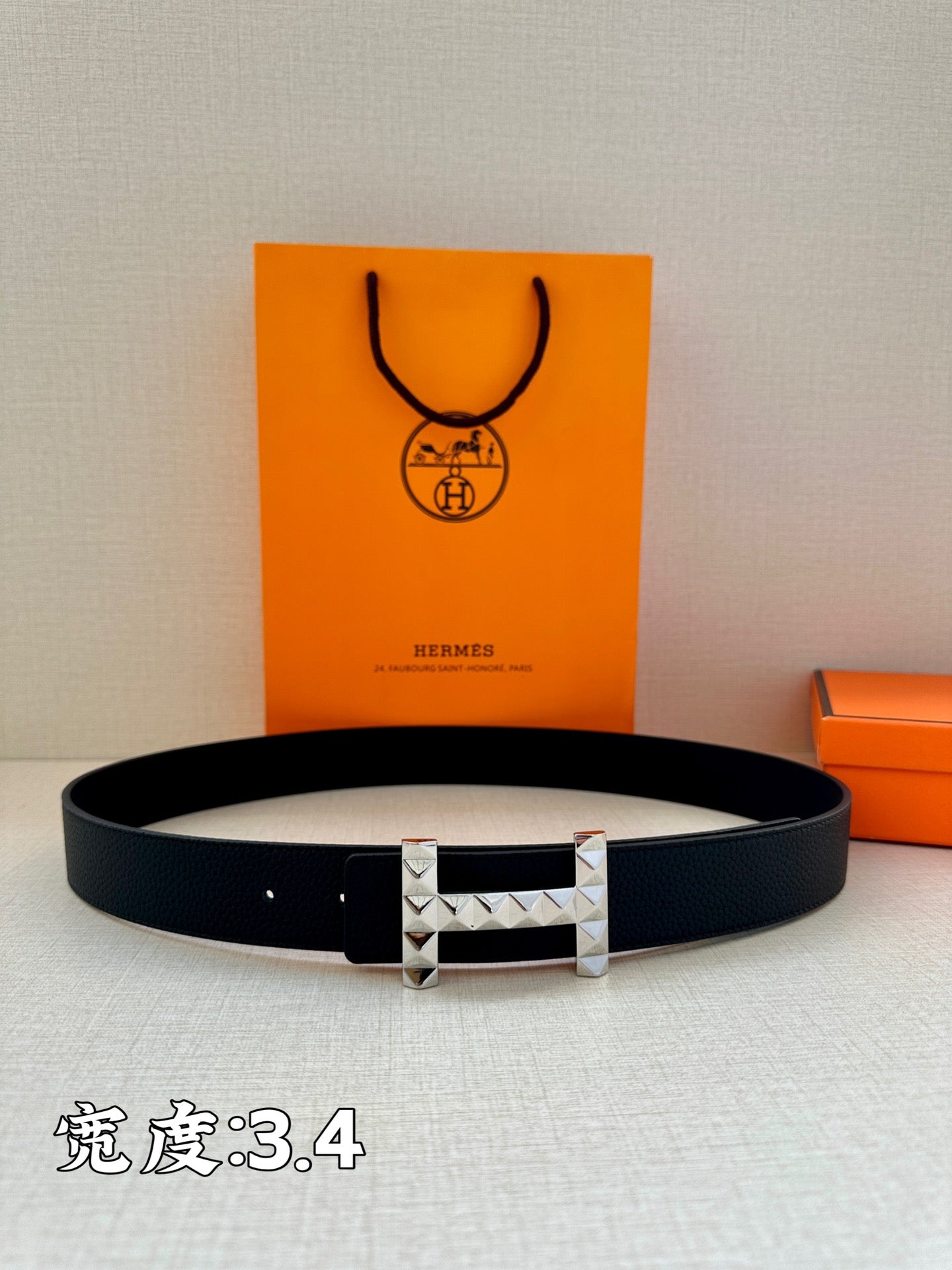 Black leather belt with silver-tone H buckle centered and facing forward.