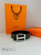 Hermes belt dark green leather with silver-tone studded H buckle on flat lay