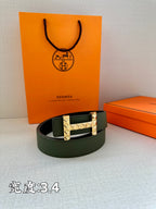 Hermes belt dark green leather with silver-tone studded H buckle, laid on surface