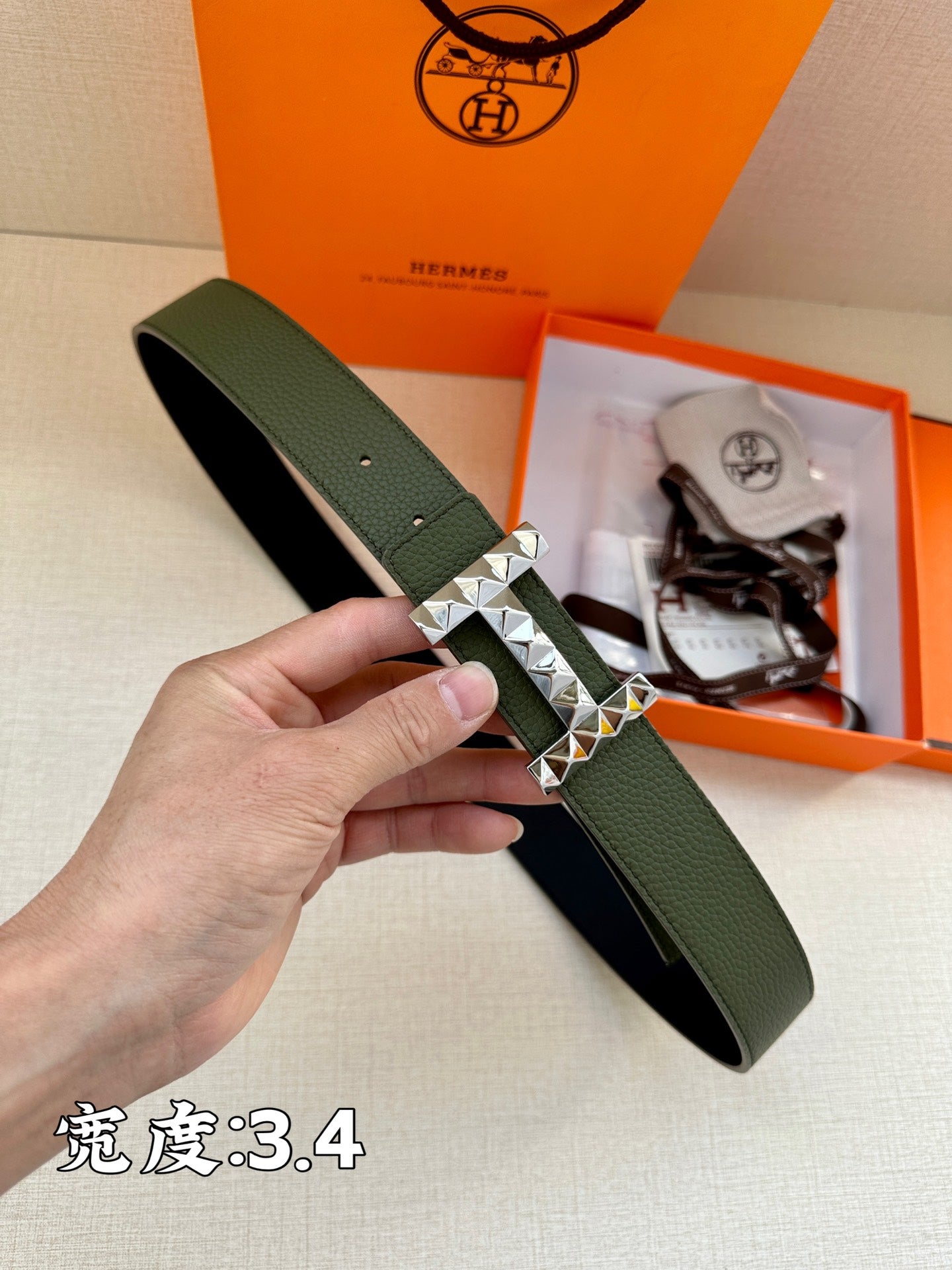 Hermes belt in dark green leather with silver-tone studded H buckle detail