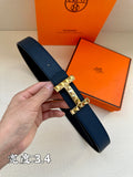 Dark blue leather belt with silver studded buckle, in hand