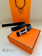 Dark blue leather belt with silver studded buckle on orange box