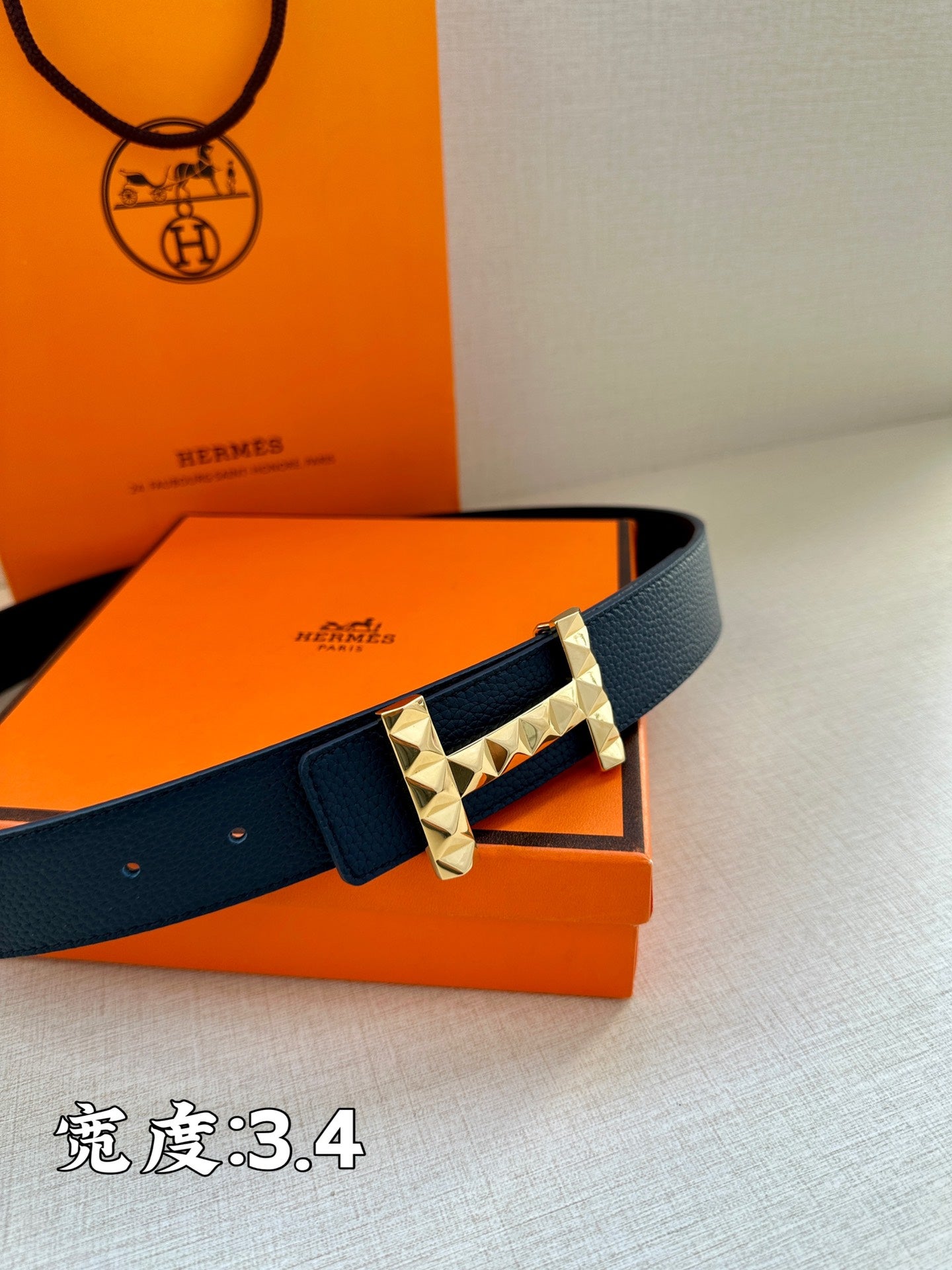 Dark blue leather belt with silver studded buckle on box