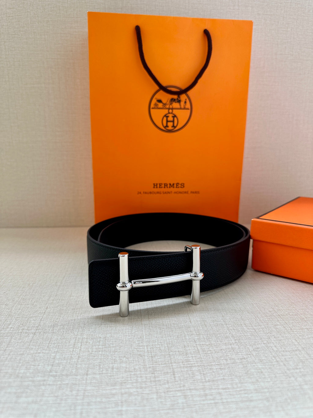 Black leather belt with silver rectangular buckle, smooth black strap