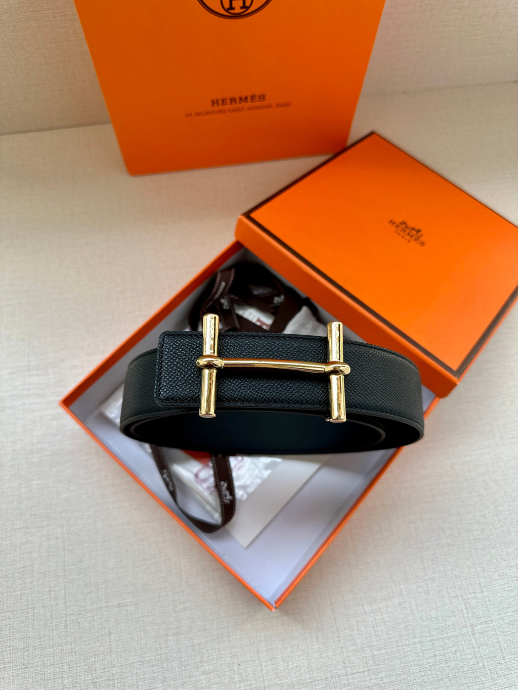 Black leather belt with gold square buckle, flat strap for fastening